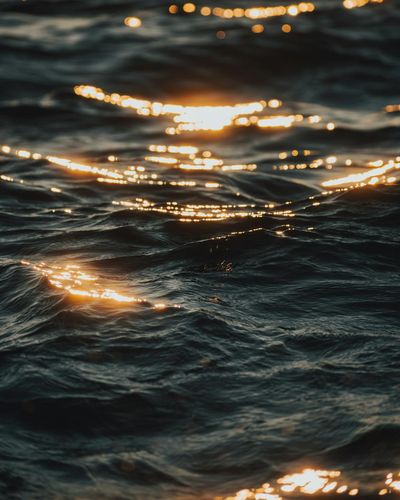 Abstract golden light reflecting on dark water surface